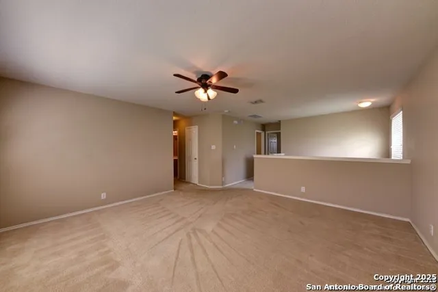 a view of an empty room with a ceiling fan