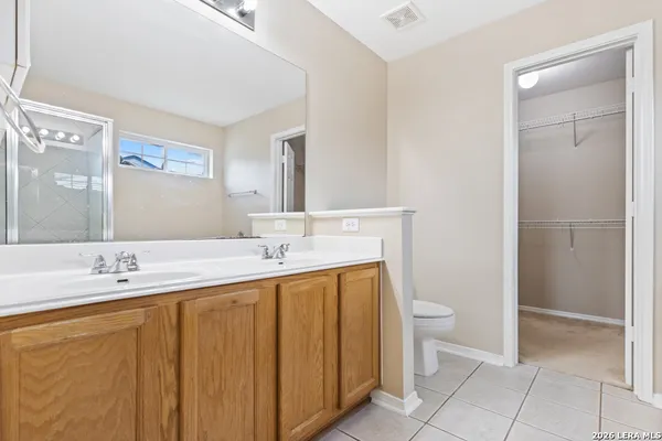 a bathroom with a double vanity sink toilet and a mirror