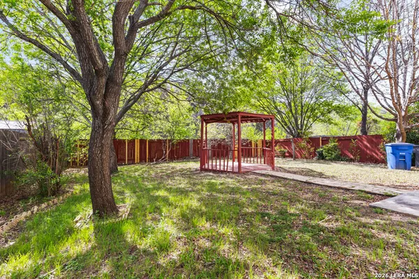 a view of a house with backyard and tree