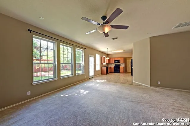 a view of a livingroom with a ceiling fan and window