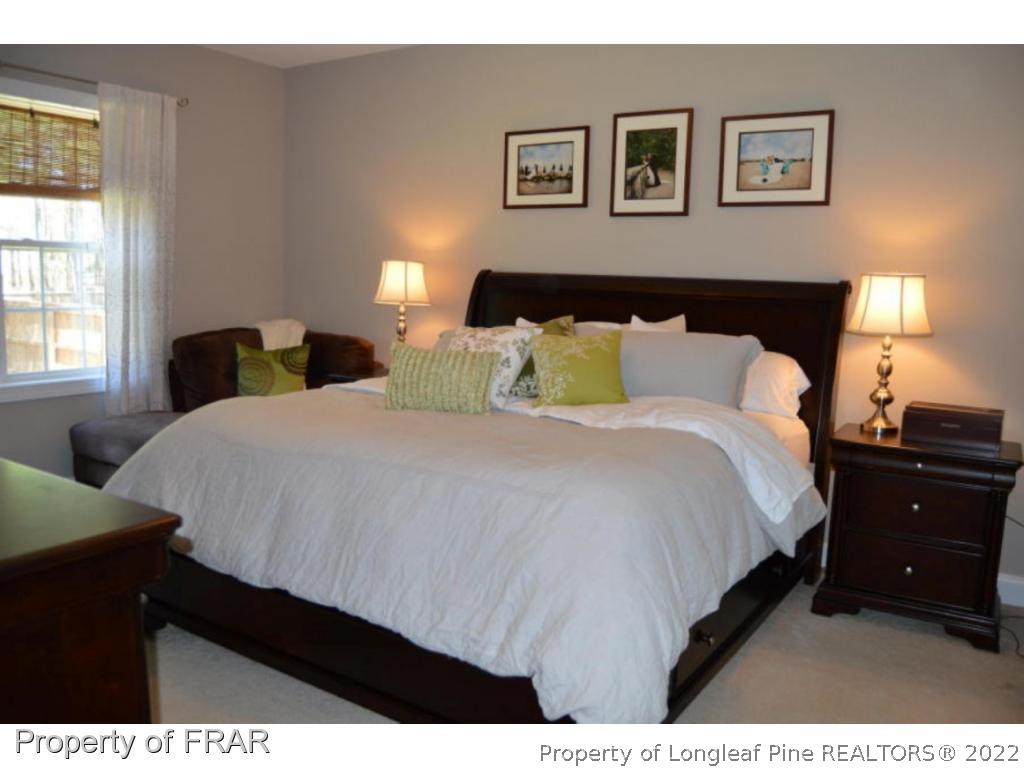 103 Sandy Springs Road Aberdeen, NC 28315 - Photo 11 of 25 a bedroom with a bed and a lamp