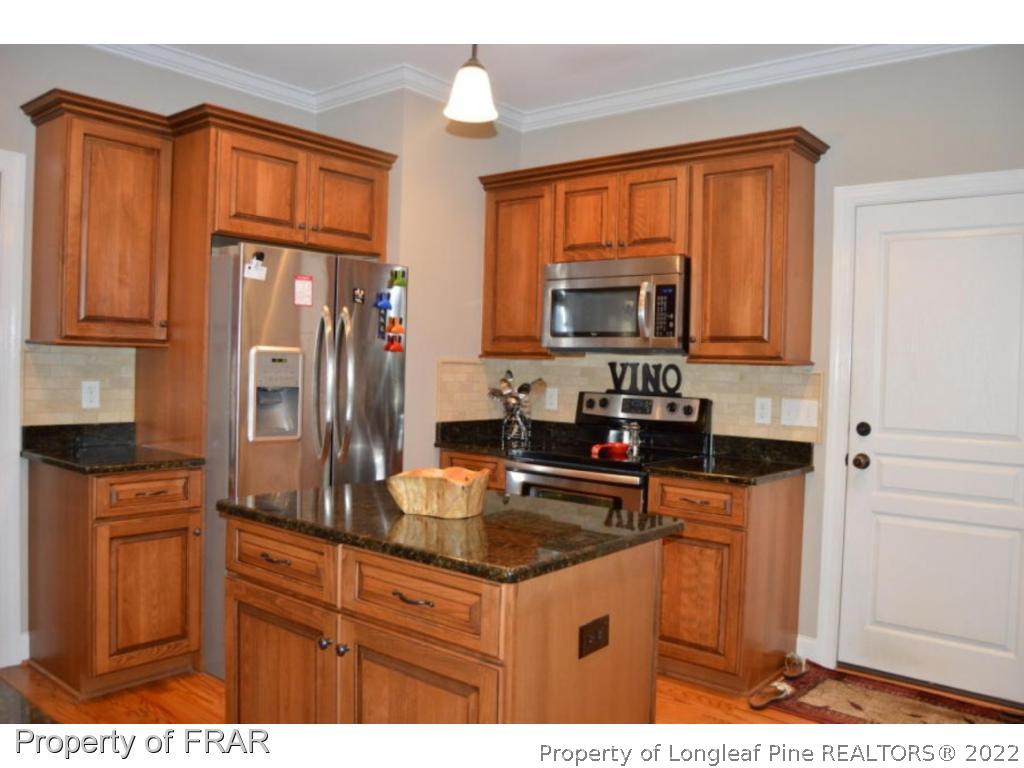 103 Sandy Springs Road Aberdeen, NC 28315 - Photo 3 of 25 a kitchen with granite countertop stainless steel appliances a stove top oven