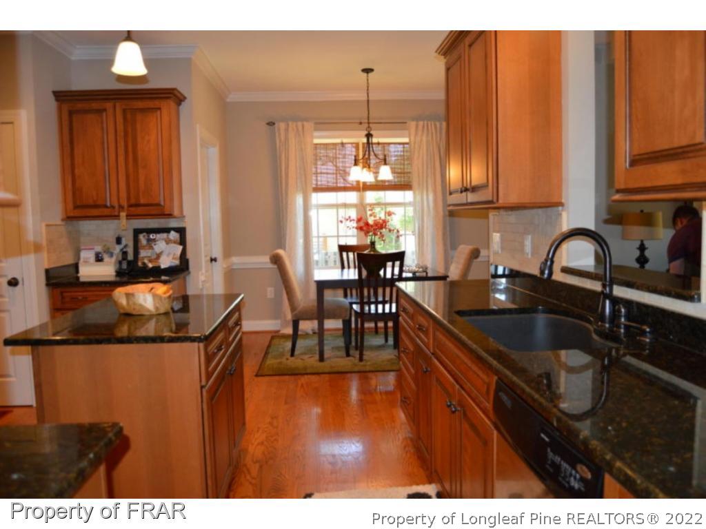 103 Sandy Springs Road Aberdeen, NC 28315 - Photo 5 of 25 a kitchen with sink a window and chairs