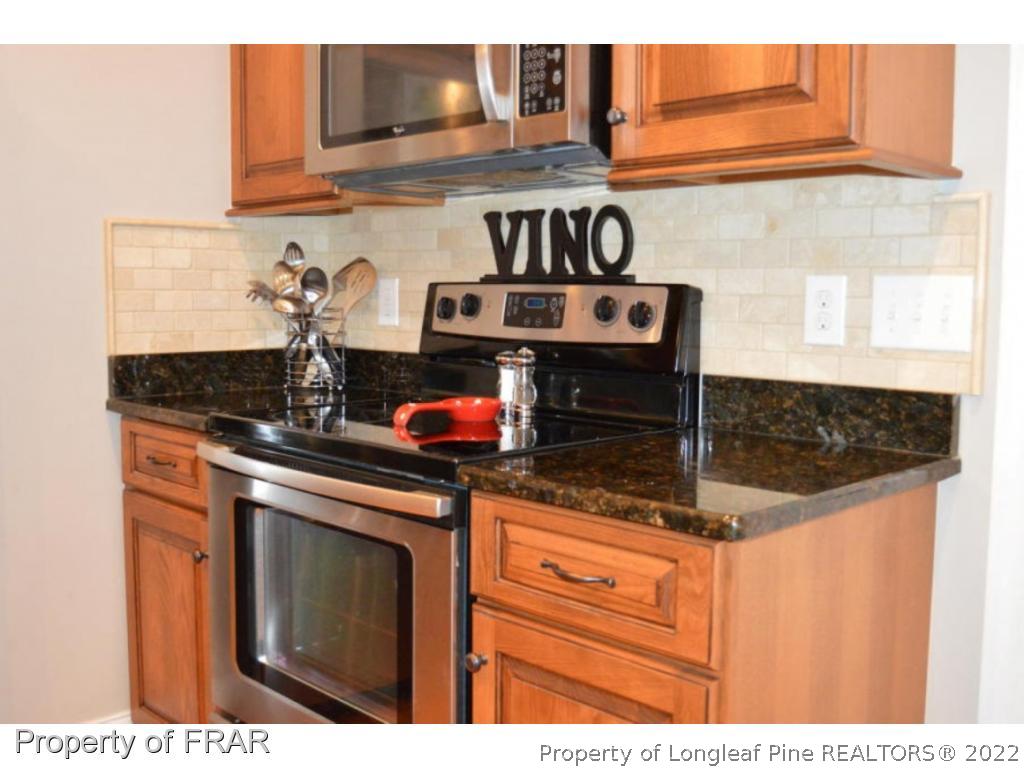 103 Sandy Springs Road Aberdeen, NC 28315 - Photo 6 of 25 a kitchen with stainless steel appliances granite countertop a stove a sink and cabinets