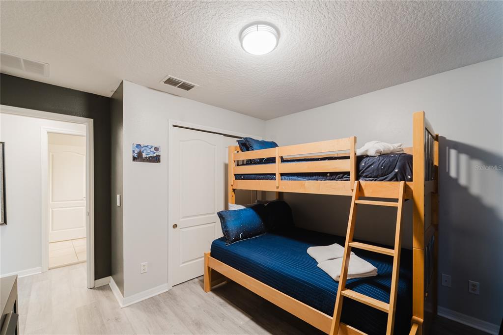 8961 Majesty Palm Road Kissimmee, FL 34747 - Photo 27 of 40 a bedroom with a bunk bed and a dresser