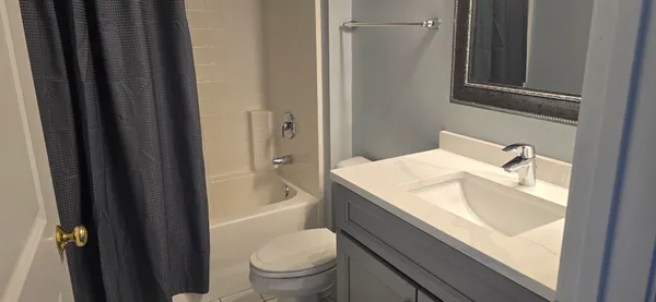 a bathroom with a granite countertop sink toilet and shower