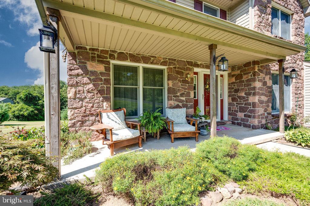 881 Zion Road Mohnton, PA 19540 - Photo 48 of 64 Charming stone porch with lush greenery.