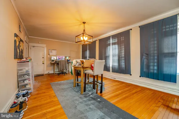 a view of a dining room with furniture a chandelier and wooden floor