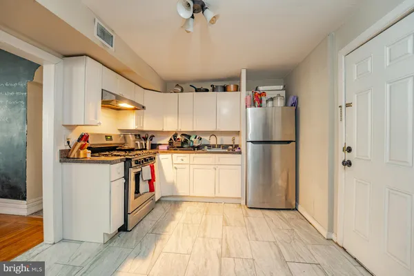 a kitchen with stainless steel appliances granite countertop a refrigerator and a stove top oven