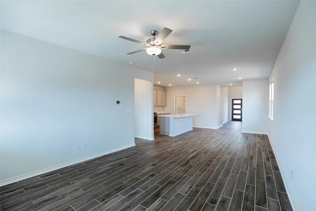a view of a kitchen with wooden floor and a ceiling fan