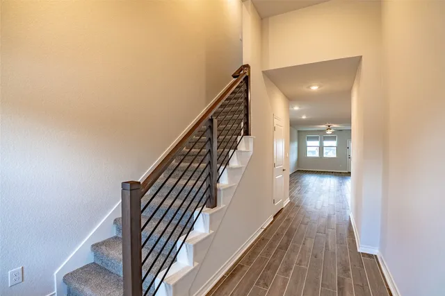 a view of a hallway with wooden floor and staircase
