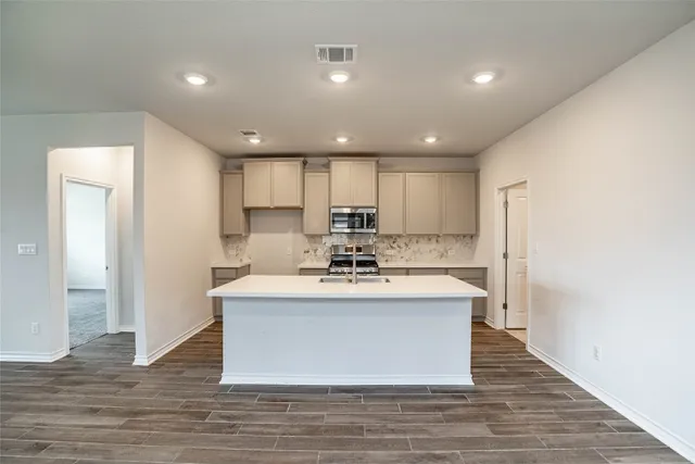 a view of kitchen with stainless steel appliances granite countertop a stove and a refrigerator