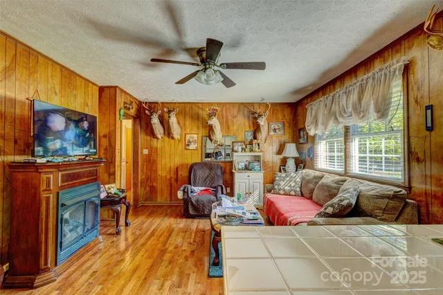 a living room with furniture a flat screen tv and a floor to ceiling window