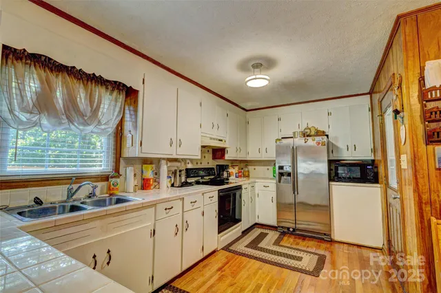 a kitchen with a refrigerator a sink and cabinets