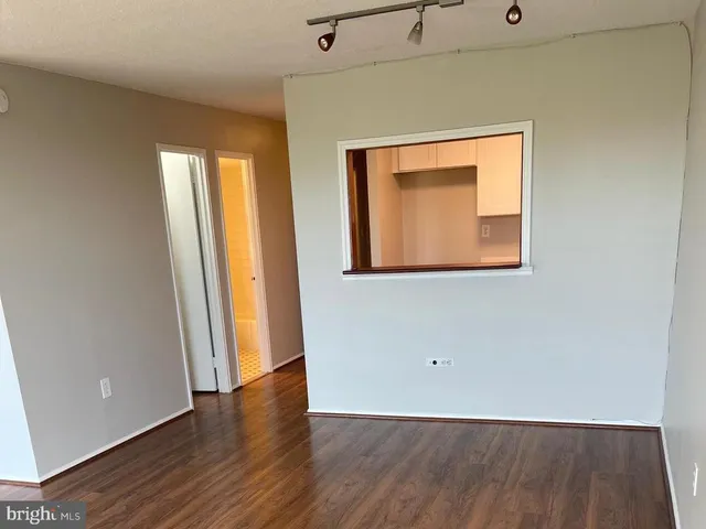 an empty room with wooden floor and a window