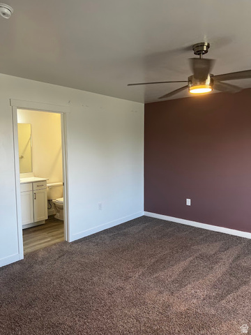 562 Hal Street, Unit 152 Tooele, UT 84074 - Photo 21 of 44 Spacious room featuring plush brown carpeting, a contemporary ceiling fan with integrated lighting, and a distinct accent wall