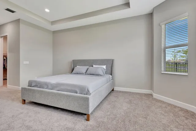 a spacious bedroom with a bed and a window