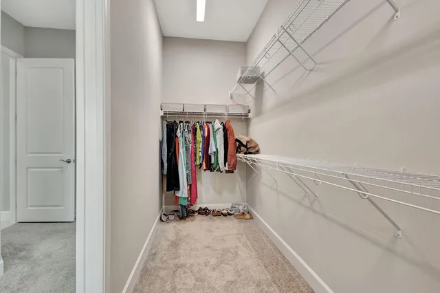 a view of walk in closet with clothes