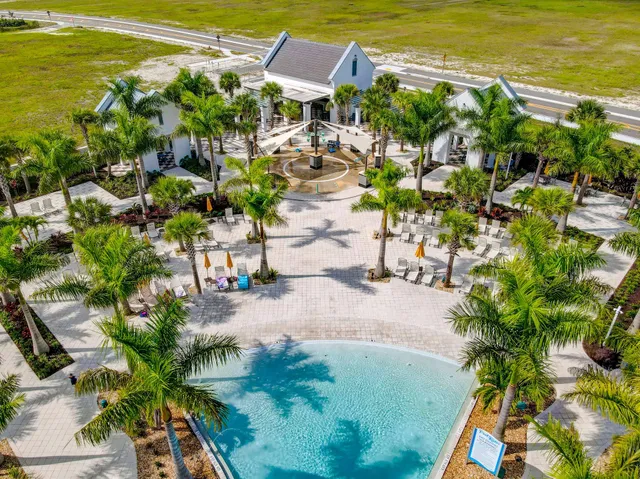 a view of a swimming pool with lawn chairs under an umbrella