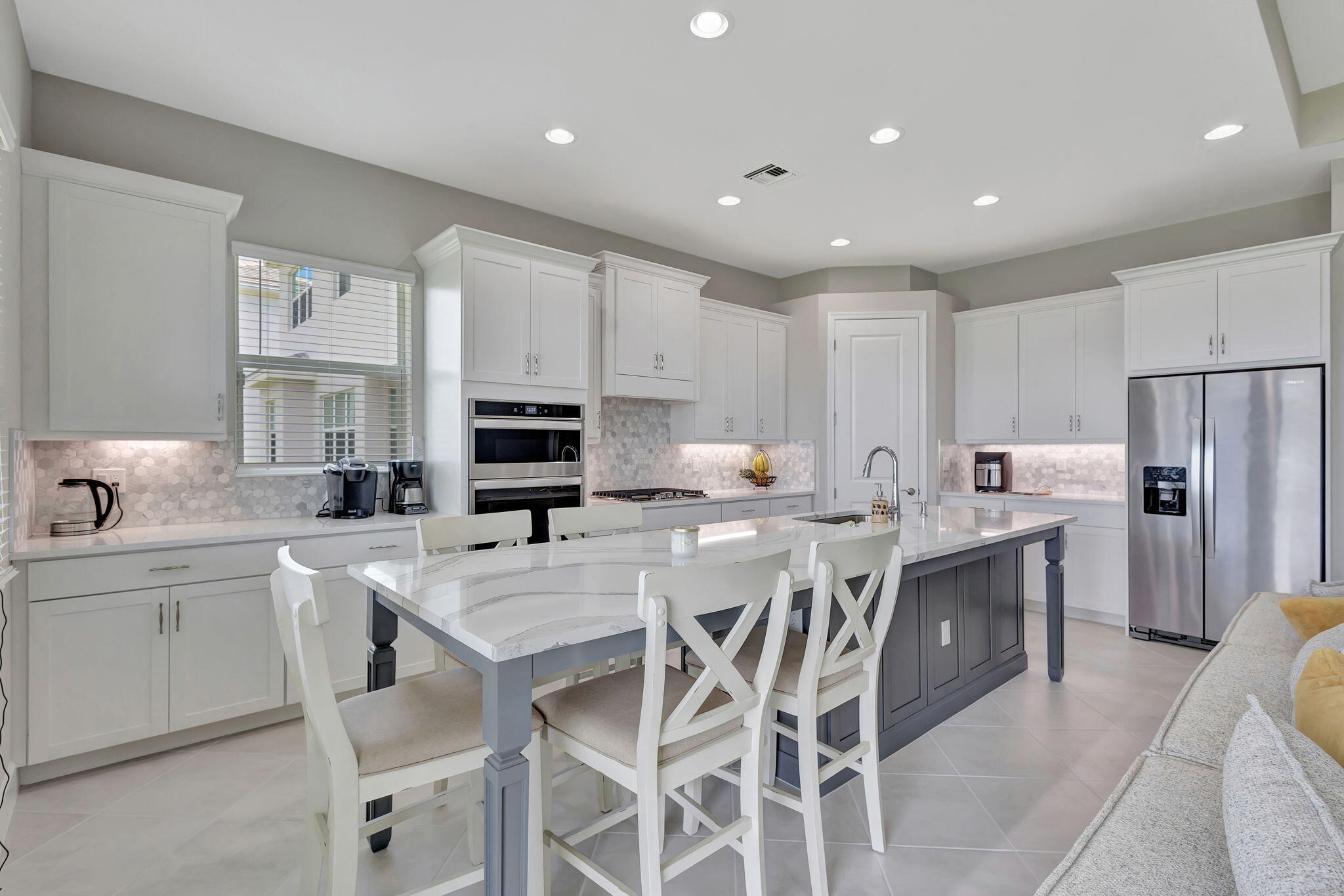 5403 Macoon Way Westlake, FL 33470 - Photo 9 of 51 a kitchen with stainless steel appliances granite countertop a table chairs sink refrigerator and microwave