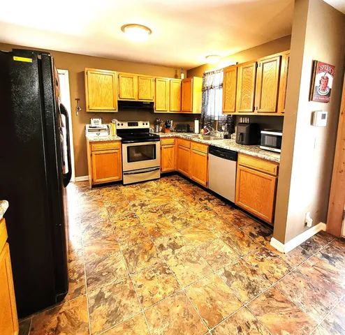 a kitchen with stainless steel appliances granite countertop a refrigerator stove top oven and sink