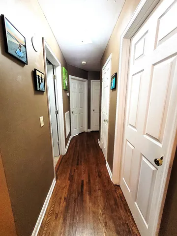 a view of a hallway with wooden floor and staircase