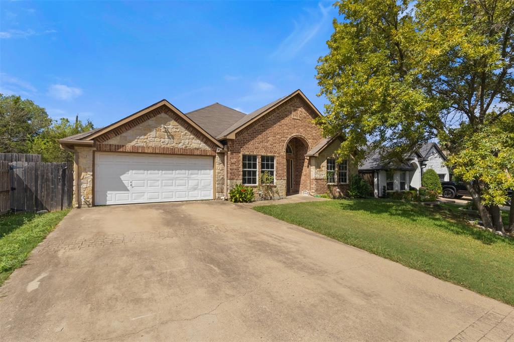490 Lynne Drive Rockwall, TX 75032 - Photo 2 of 27 View of front of property featuring driveway, stone siding, brick siding, and a garage