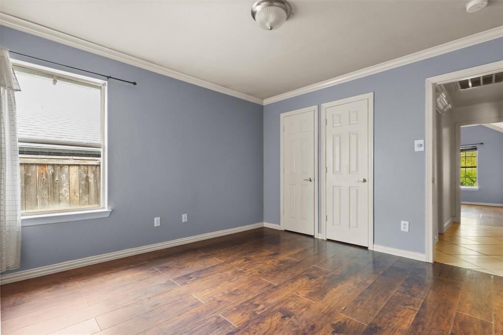 490 Lynne Drive Rockwall, TX 75032 - Photo 21 of 27 Unfurnished bedroom featuring dark wood finished floors, crown molding, and multiple closets