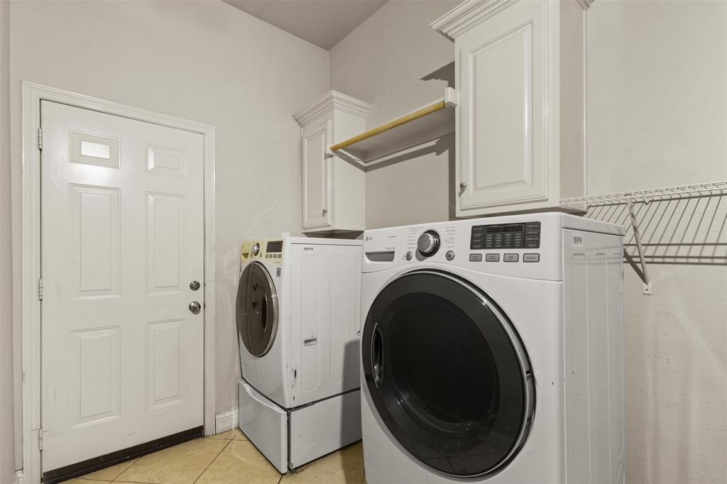 490 Lynne Drive Rockwall, TX 75032 - Photo 24 of 27 Washroom featuring light tile patterned floors, cabinet space, and washer and clothes dryer
