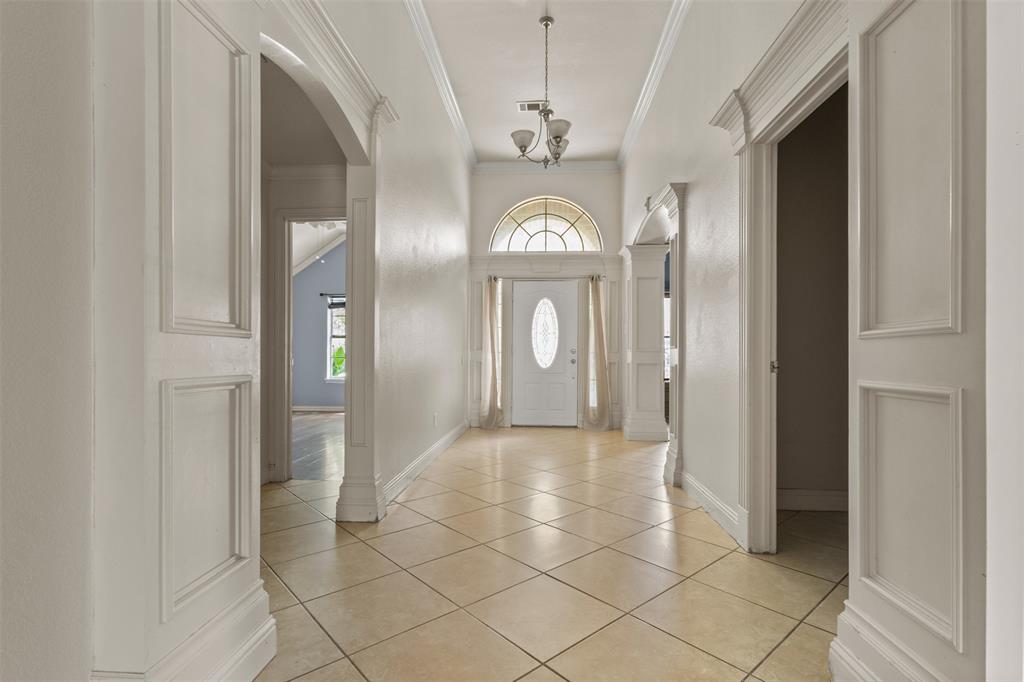 490 Lynne Drive Rockwall, TX 75032 - Photo 3 of 27 Foyer featuring light tile patterned floors, plenty of natural light, arched walkways, and ornamental molding
