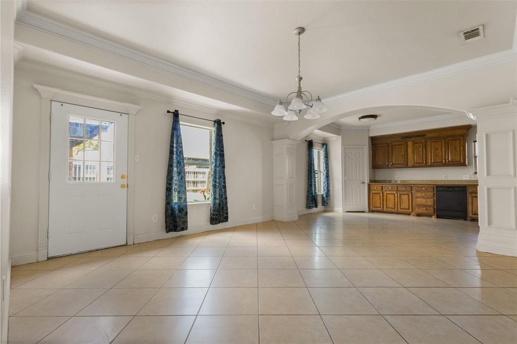 490 Lynne Drive Rockwall, TX 75032 - Photo 8 of 27 Unfurnished dining area with arched walkways, crown molding, light tile patterned floors, and a chandelier