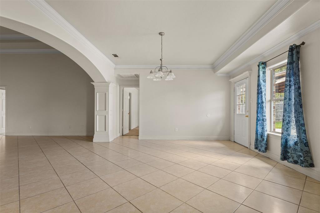 490 Lynne Drive Rockwall, TX 75032 - Photo 9 of 27 Unfurnished room with light tile patterned flooring, crown molding, arched walkways, and a chandelier