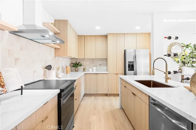 a kitchen with stainless steel appliances granite countertop a sink stove and refrigerator