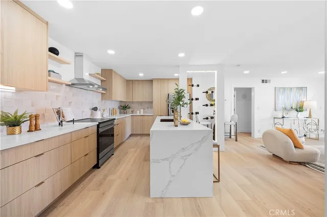 a large white kitchen with cabinets and wooden floor