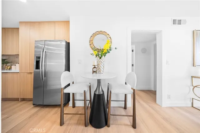 a living room with stainless steel appliances furniture a rug and a chandelier