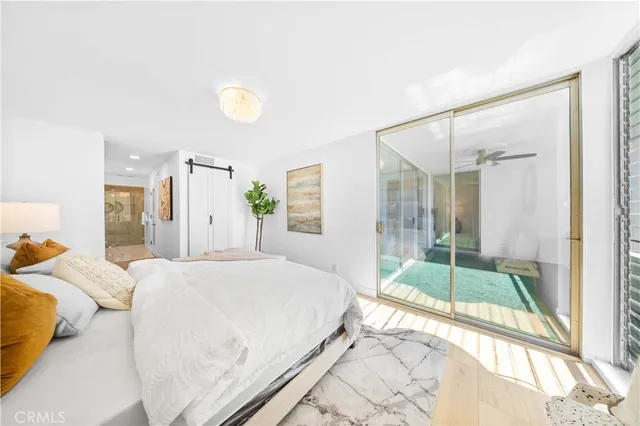 a bedroom with a bed and a large window