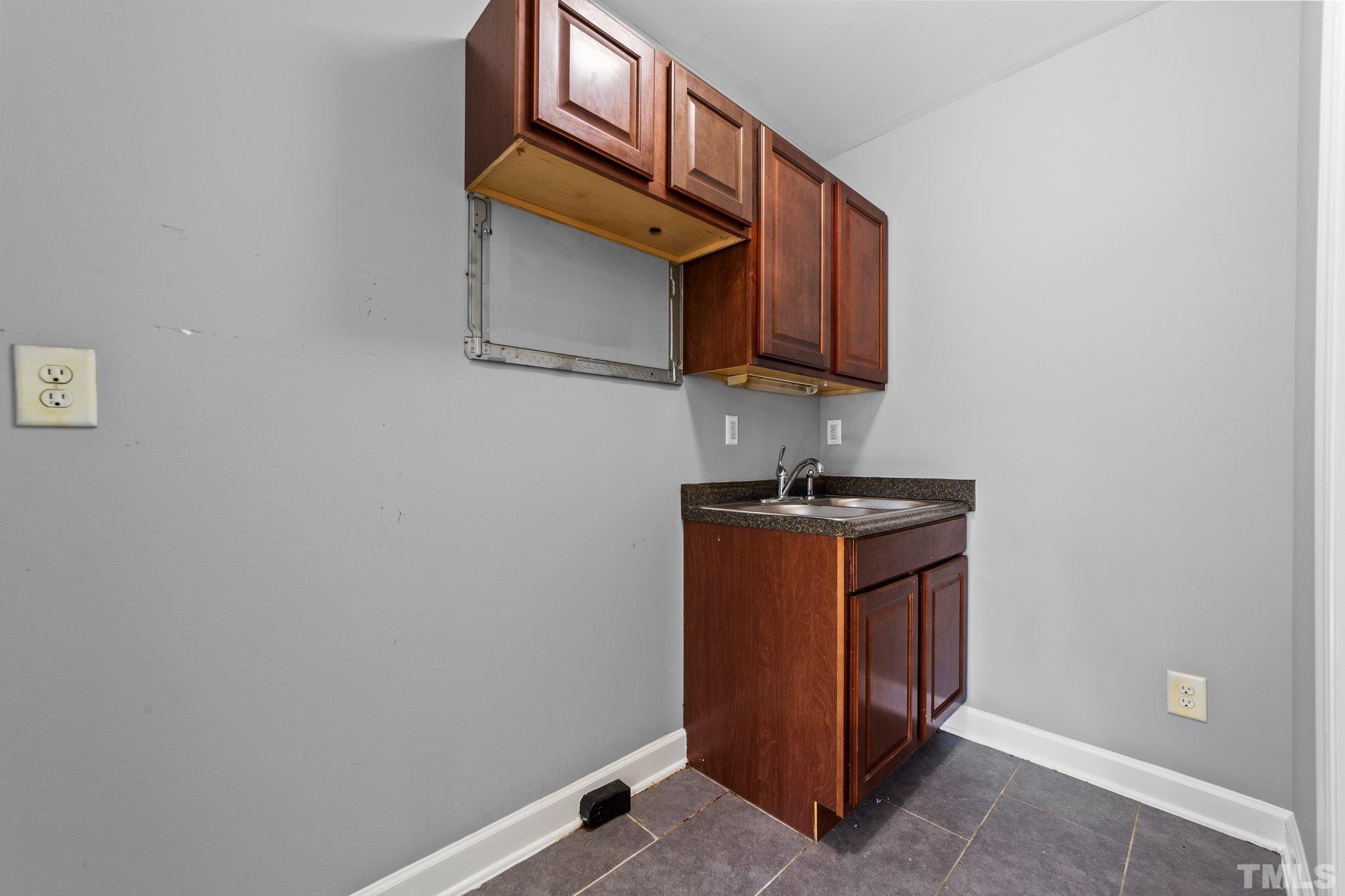 198 Garrett Street Roxboro, NC 27573 - Photo 8 of 17 a room with wooden cabinets and a window