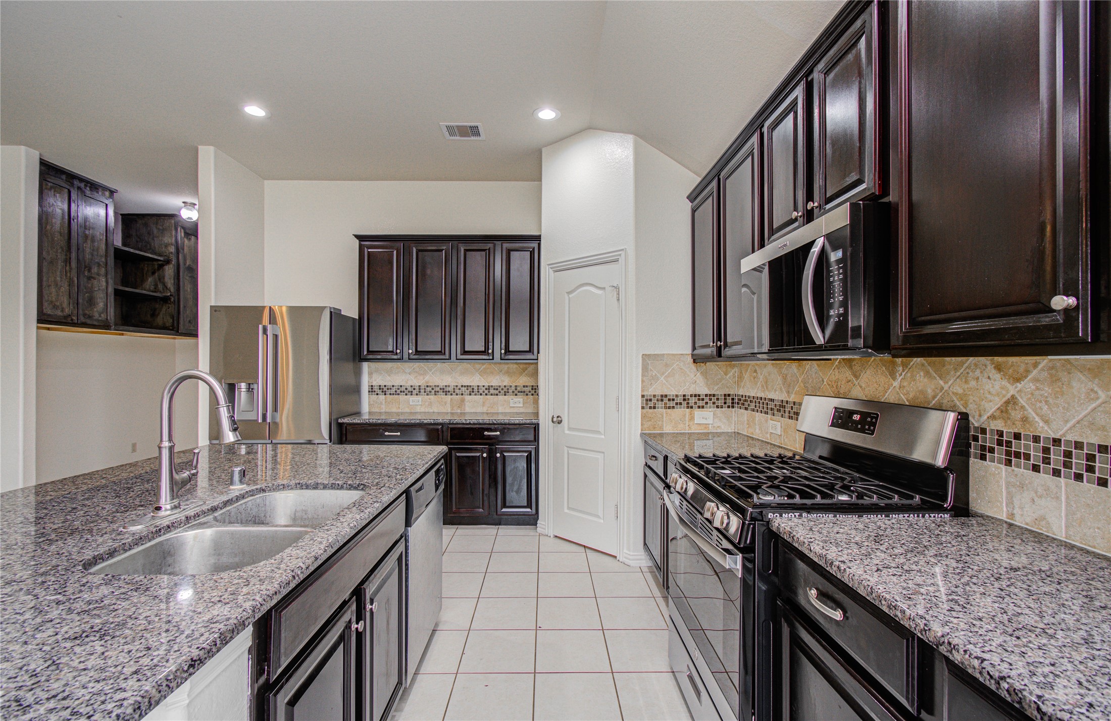 17702 Jacobs Ladder Court Tomball, TX 77377 - Photo 13 of 36 a kitchen with stainless steel appliances granite countertop a sink stove microwave and refrigerator