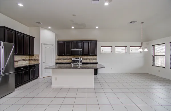 a kitchen with stainless steel appliances a sink stove and cabinets