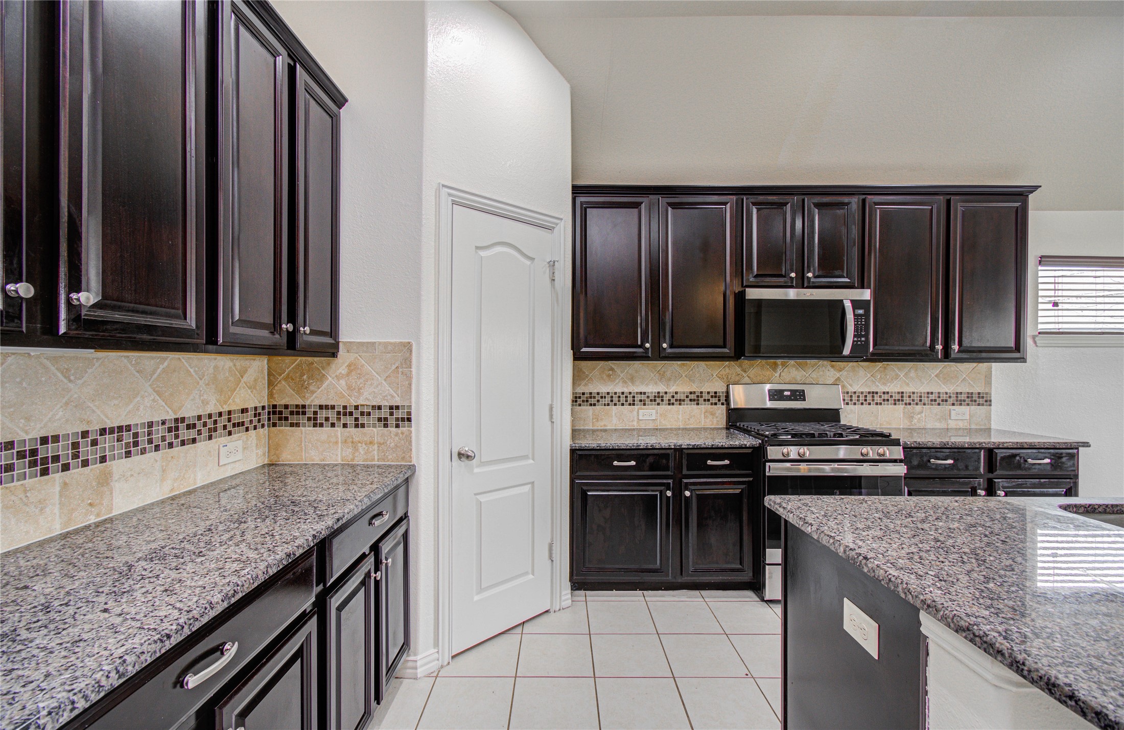 17702 Jacobs Ladder Court Tomball, TX 77377 - Photo 18 of 36 a kitchen with stainless steel appliances granite countertop a stove a sink and a microwave