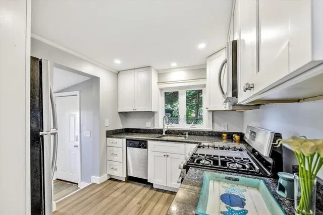 a kitchen with white cabinets and appliances