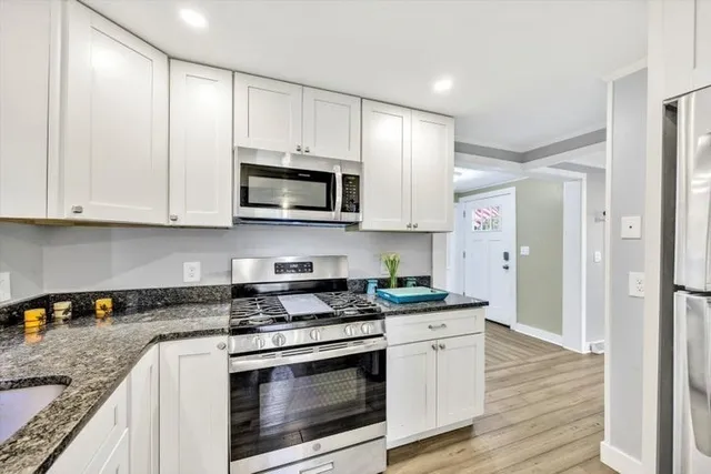 a kitchen with stainless steel appliances granite countertop a stove a microwave and a refrigerator