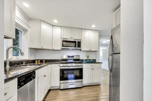 a kitchen with stainless steel appliances granite countertop a stove a refrigerator and a microwave