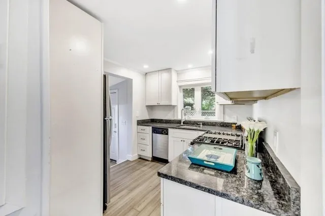 a kitchen with stainless steel appliances granite countertop a stove a sink and a refrigerator