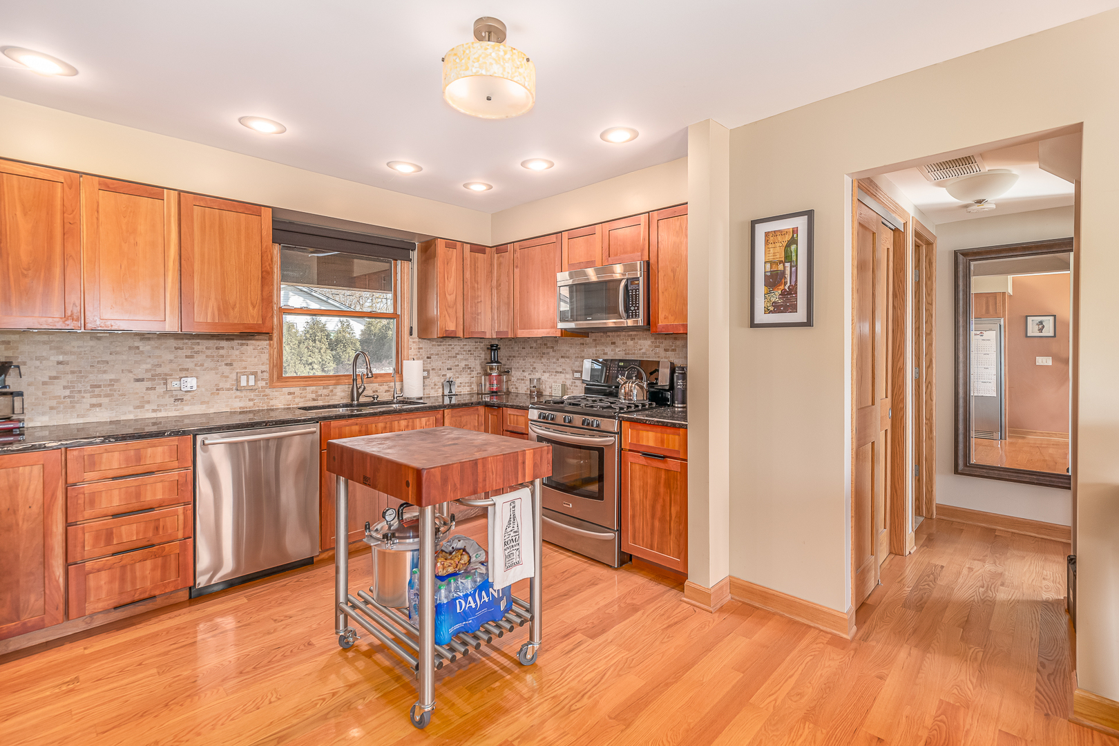 181 Queenswood Road Bolingbrook, IL 60440 - Photo 11 of 46 a kitchen with stainless steel appliances granite countertop wooden cabinets a center island and a window