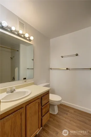 a bathroom with a sink a toilet and a mirror