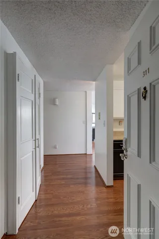 a view of a hallway with wooden floor and windows