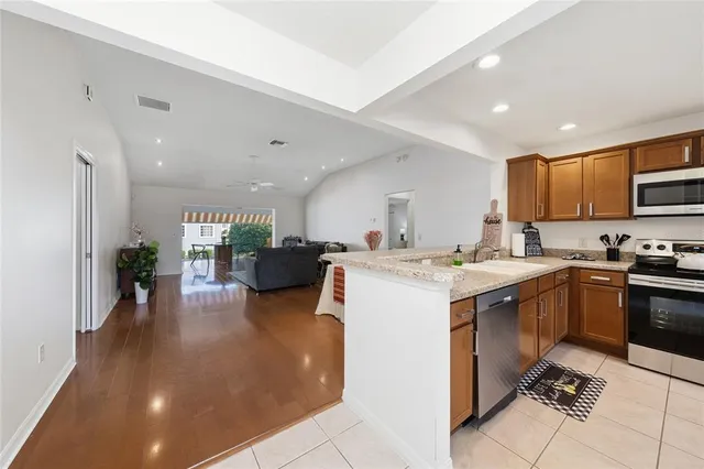 a kitchen with stainless steel appliances kitchen island granite countertop a sink and cabinets