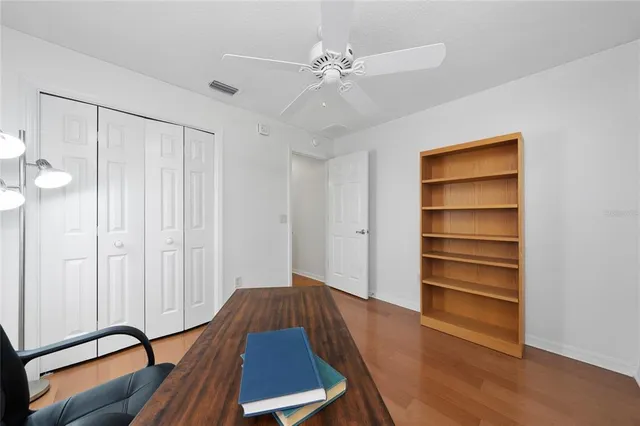 a view of room with wooden floor and fan