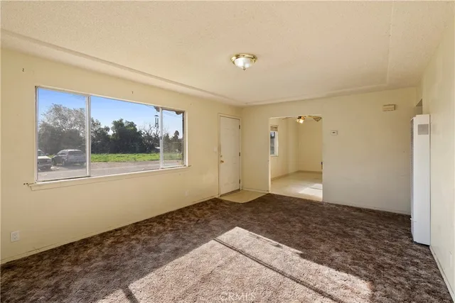 a view of empty room with window and wooden floor